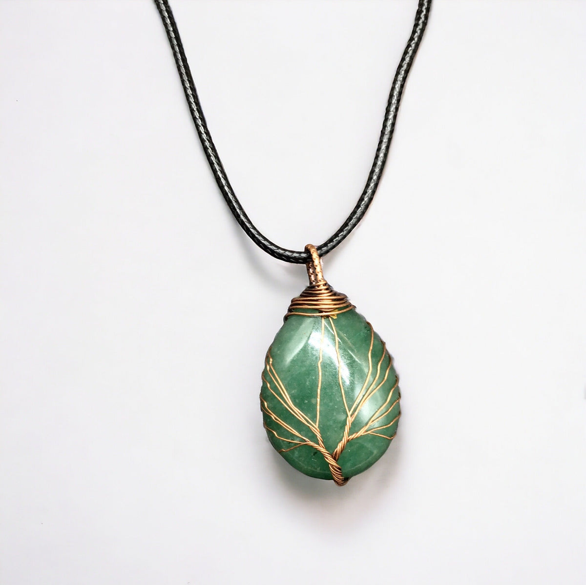 Pendentif en pierre précieuse verte entouré d'un arbre de vie doré