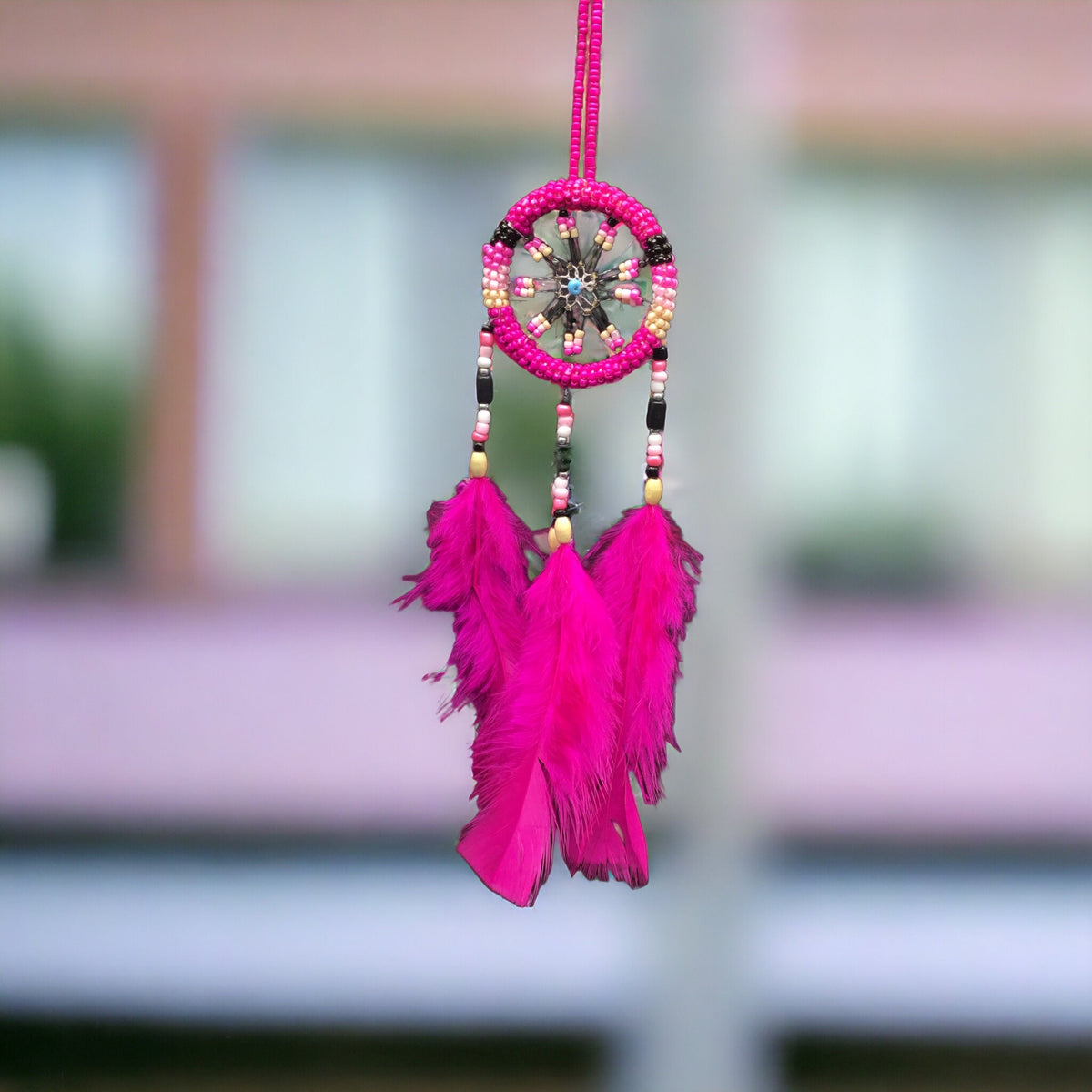 Petit attrape-rêves rose fait à la main avec des plumes roses