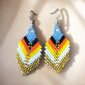 Boucles d'oreilles pendantes à perles et plumes bleu ciel et dorées