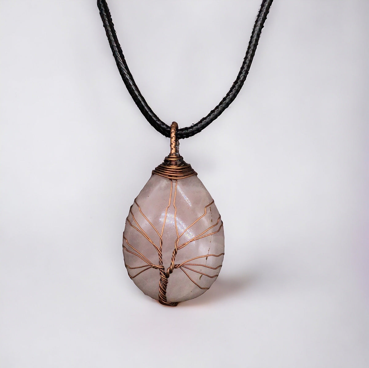 Pendentif gemme rose clair enveloppé d'un arbre de vie en bronze